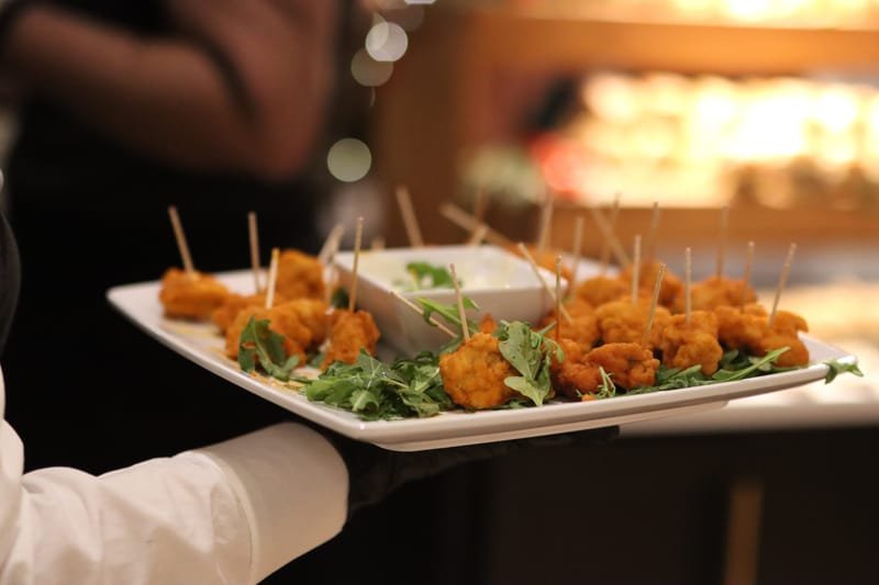 Server carrying a tray of passed appetizers at an event